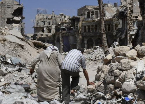 Two persons walk in the ruins of Aleppo, Syria