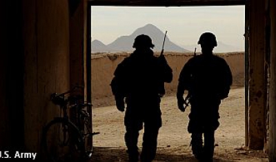 Two US soldiers walking out of a building