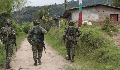 3 Soldiers walking on a dirt road