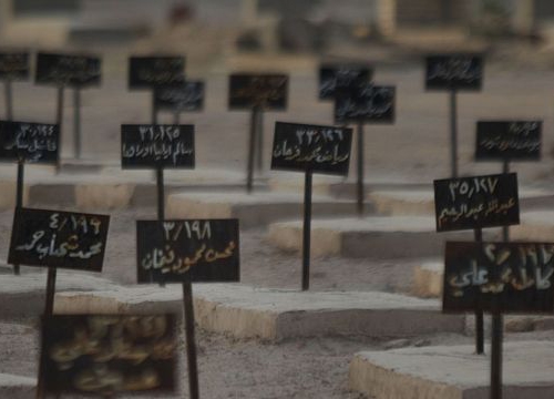 Man sitting in front of a graveyard (tombstones in arabic)