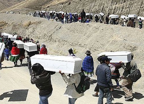 Group of people carrying coffins down the mountain