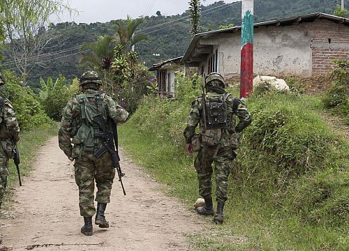 3 Soldiers walking on a dirt road