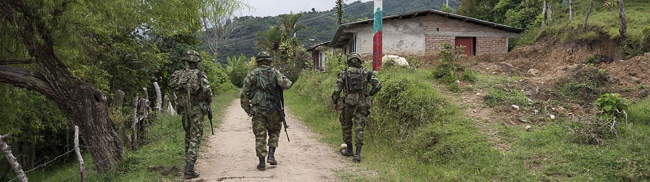 3 Soldiers walking on a dirt road