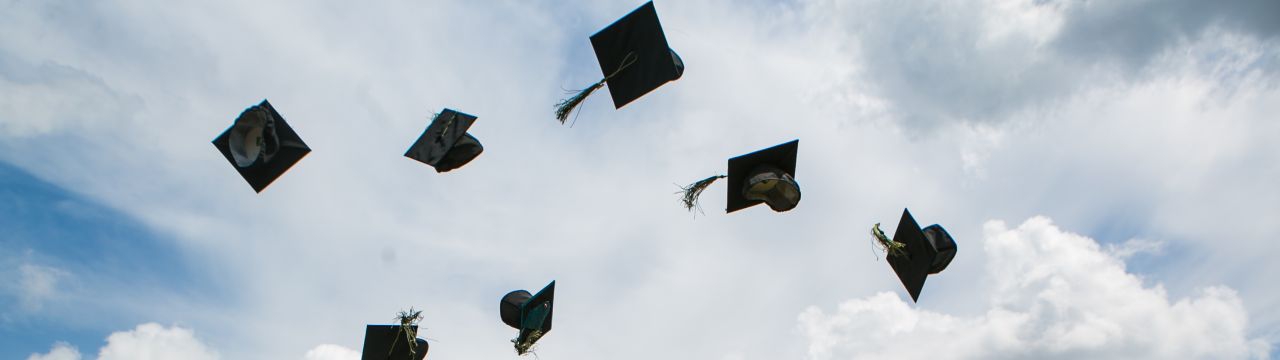 Gradutation hats thrown in the air