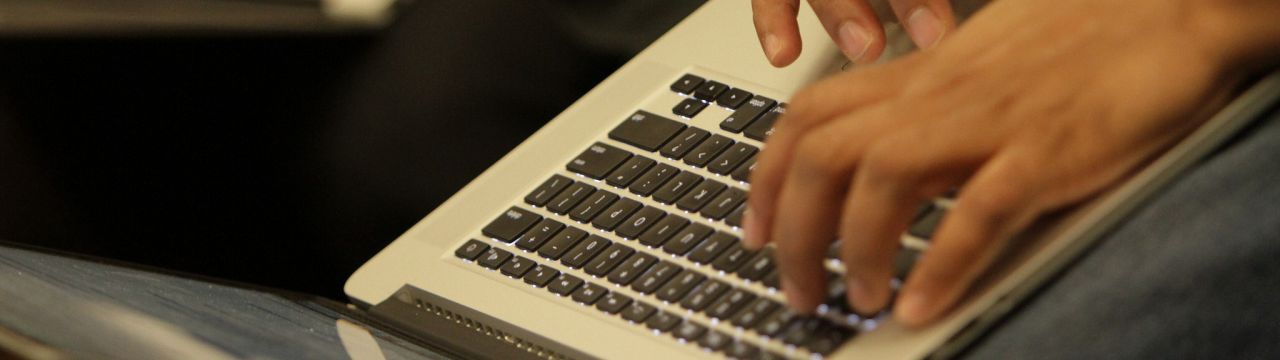 Hands typing on a laptop