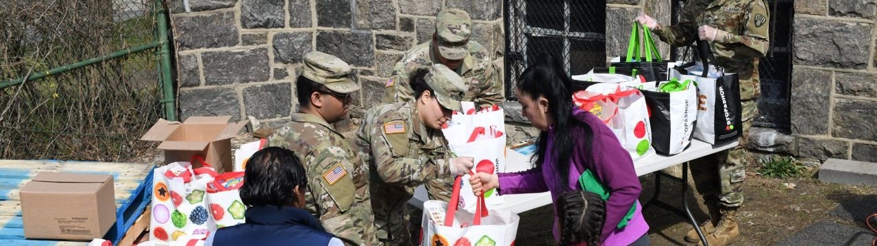 New York National Guard Soldiers from the 101st Signal Battalion hand groceries to members of the community at a food distribution point at Hope Community Services in New Rochelle on March 18, 2020.