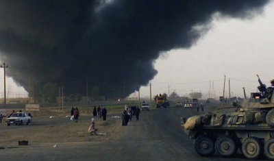 Smoke from a burning oil field rises into the air, Iraq, 2006