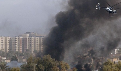 A Blackwater Security Company MD-530F helicopter aids in securing the site of a car bomb explosion in Baghdad, Iraq, on December 4, 2004, during Operation IRAQI FREEDOM