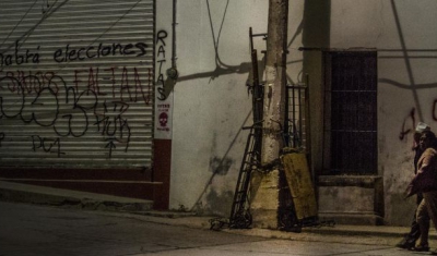 Mexico, two persons walk in th street at night