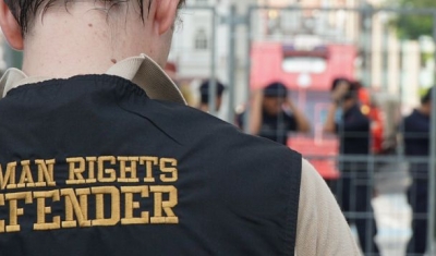 A human rights defender before a police barrage