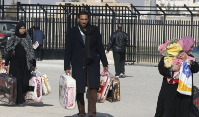 Syrian Refugees leave a blanket distribution center in Mafraq, Jordan.