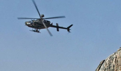 First Lt. Peter Cacossa directs an OH-58 Kiowa helicopter from a rooftop toward the sound of small-arms fire heard during a raid in Mosul, Iraq, April 17, 2008. 