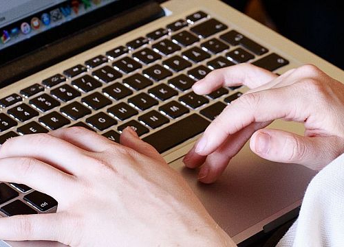 Geneva Academy student taking notes on a laptop