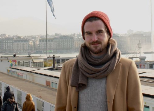 Alexis Comninos, LLM student at the Geneva Academy, in front of the Bains des Pâquis