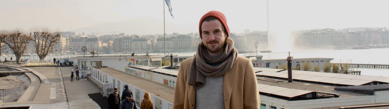 Alexis Comninos, LLM student at the Geneva Academy, in front of the Bains des Pâquis