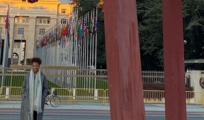 Portrait of Ely Cossio in from of the broken chair at the Place des Nations in Geneva