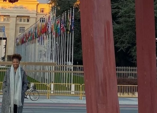 Portrait of Ely Cossio in from of the broken chair at the Place des Nations in Geneva