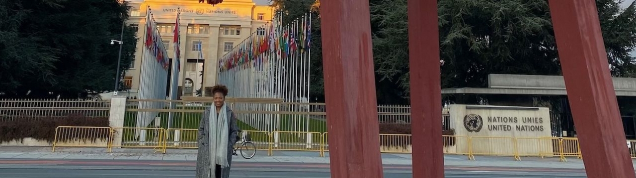 Portrait of Ely Cossio in from of the broken chair at the Place des Nations in Geneva