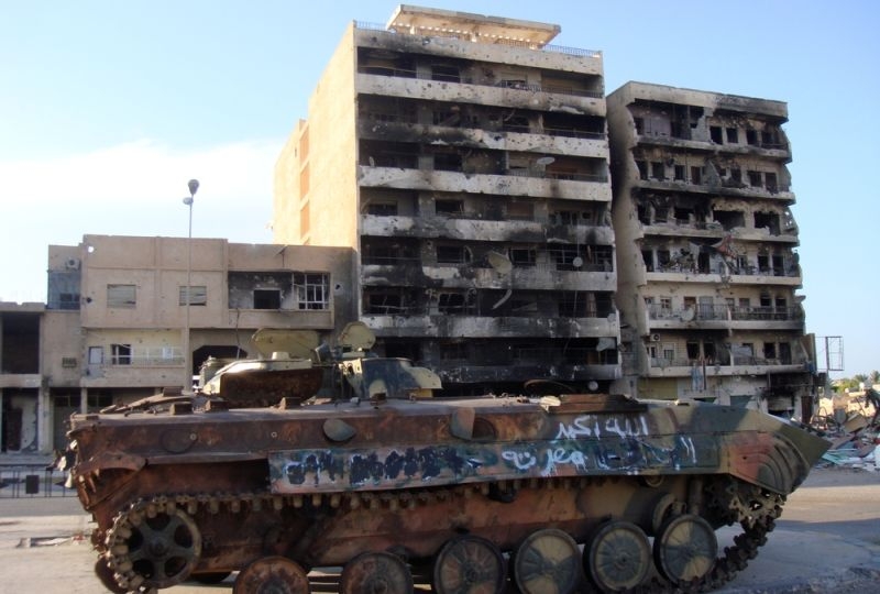 A thank in fron of a destroyed building in Misrata, Libya