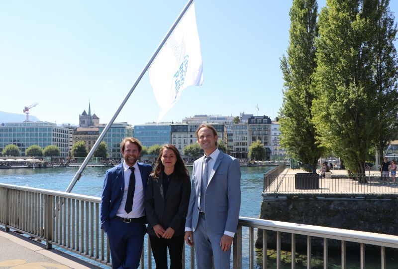 Geneva Human Rights Platform's tream on the Mont-Blanc bridge, with the flag of the platform behind