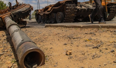 A man passes by a destroyed tank on the main street of Edaga Hamus, in the Tigray region, in Ethiopia, on June 5, 2021